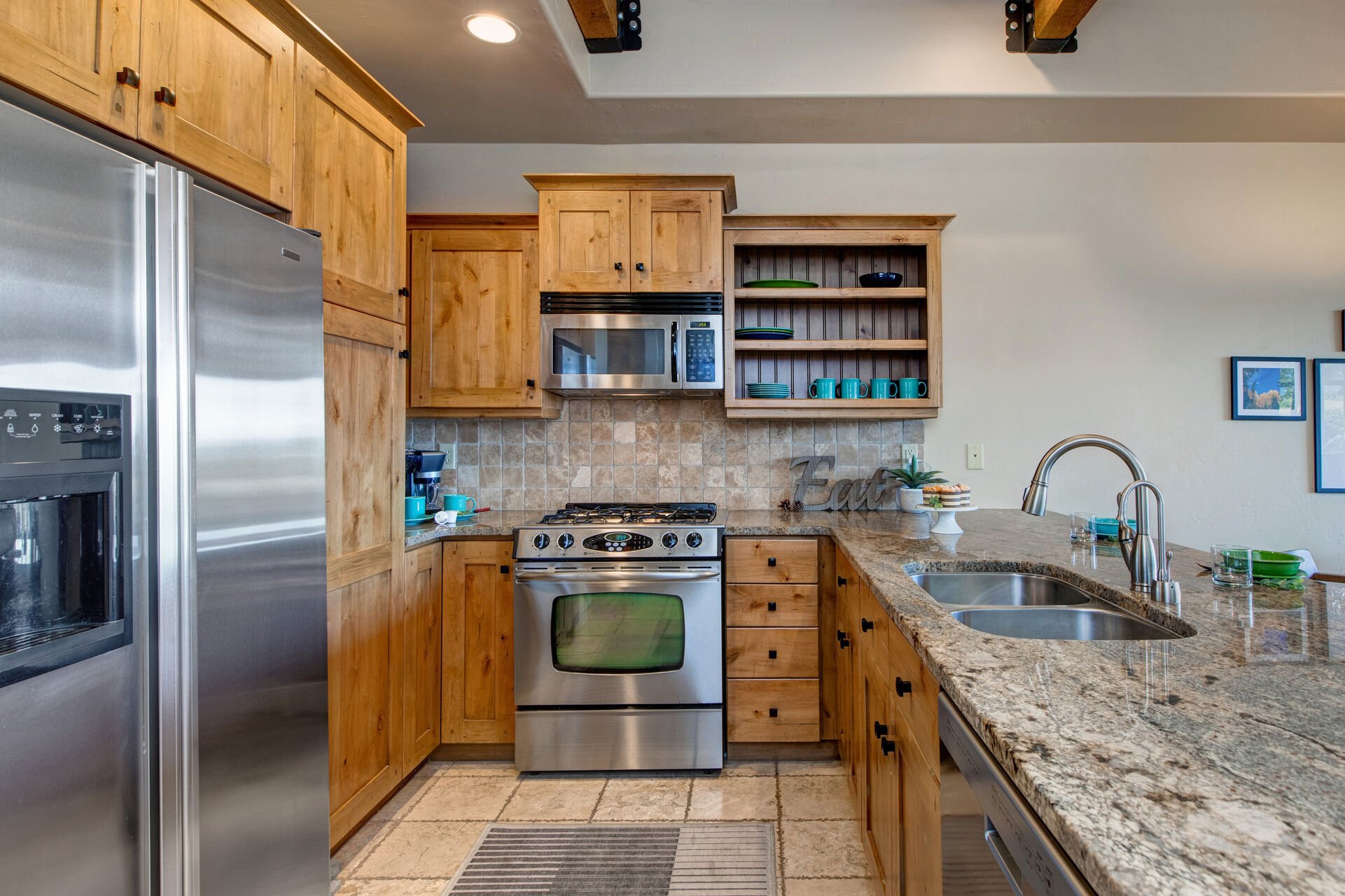 Fully Equipped Kitchen with stone countertops, stainless steel appliances, ice maker, and bar seating for three