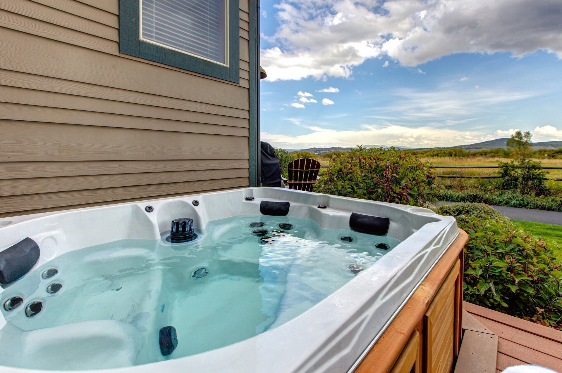 Main Level private patio with hot tub, seating and table for two, and beautiful surrounding views