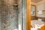 Master Bathroom with dual vanities, tiled shower, and large jetted soaking tub