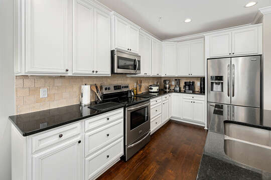 Stainless steel appliances compliment the crisp, white Kitchen.
