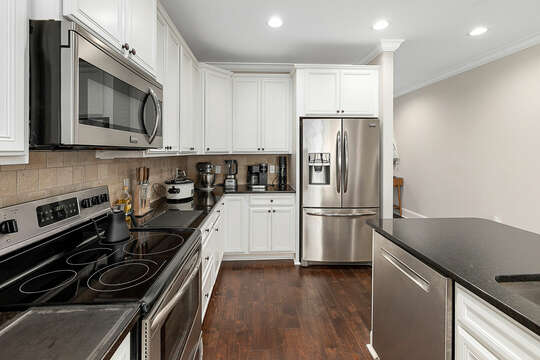 Stainless steel appliances compliment the crisp, white Kitchen.