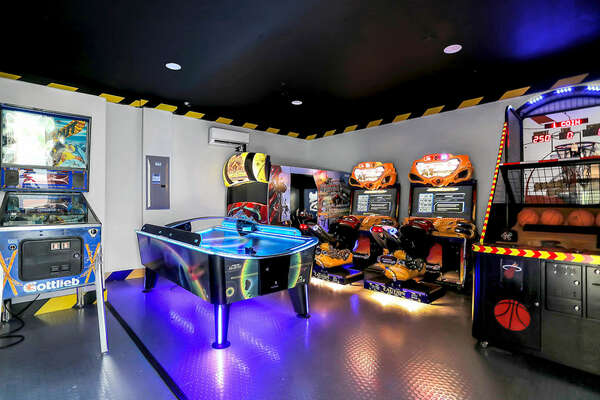 Arcade room with commercial air hockey, arcade Basketball, Dead-storm Pirates arcade, Super Bikes 2 dual racer, and a pinball machine