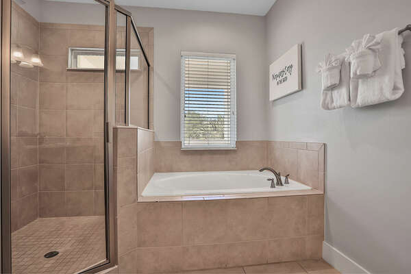 En suite bathroom with walk-in shower, garden tub, and dual vanity