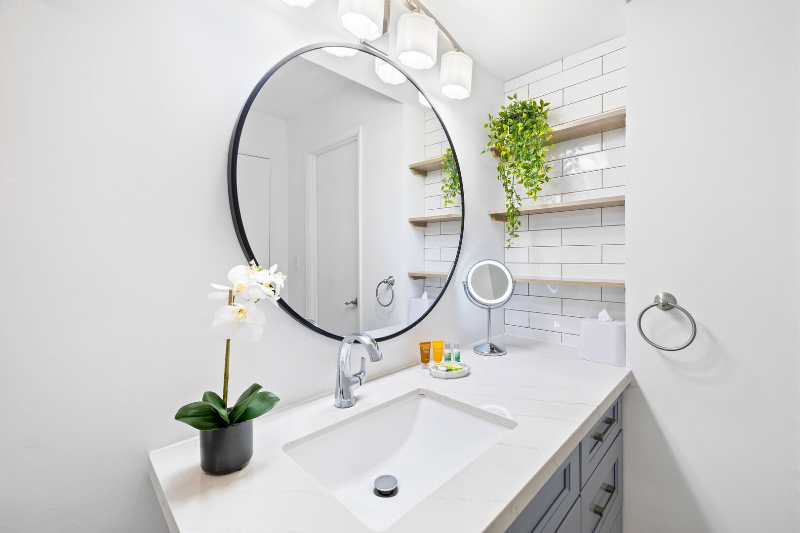 Well-lit bathroom with storage shelves
