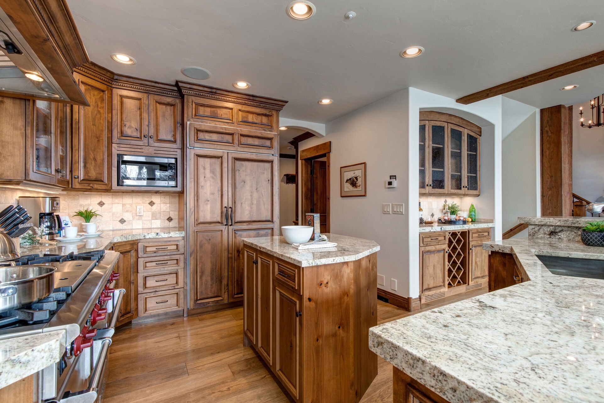 Fully Equipped Kitchen with stainless steel Wolff appliances, sub-zero fridge, double ovens, gorgeous stone countertops, separate island, and bar seating for 5