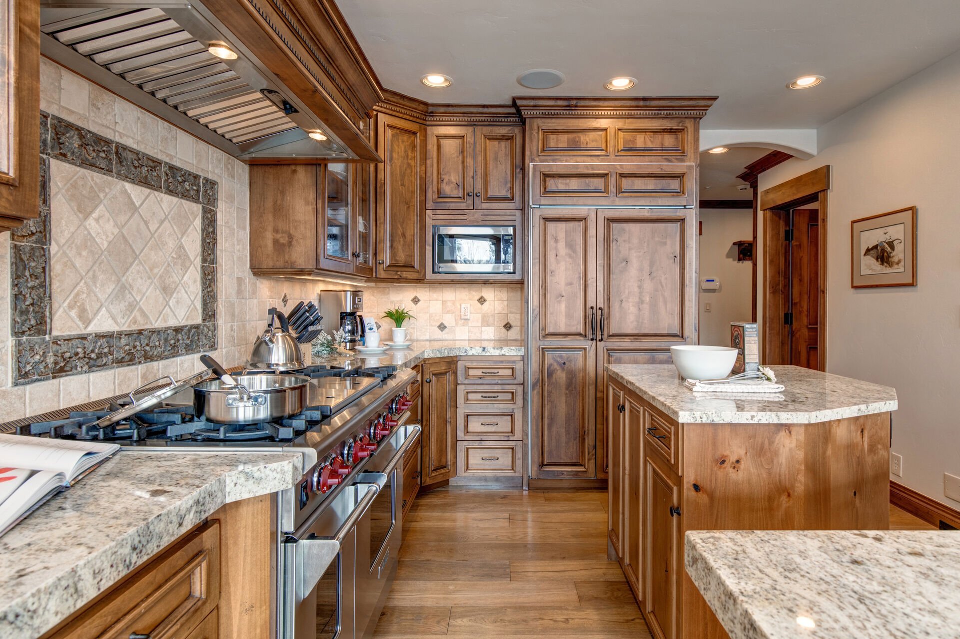 Fully Equipped Kitchen with stainless steel Wolff appliances, sub-zero fridge, double ovens, gorgeous stone countertops, separate island, and bar seating for 5