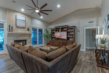 Chic and stylish great room has a gas fireplace, large TV and doors to the amazing backyard.