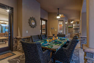 Good living begins here in the outdoor covered dining area with large TV and views of the heated pool and spa.