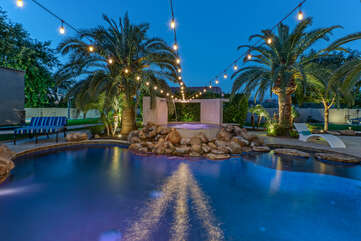 The backyard at JUNIPER OASIS with its heated pool, spa, waterslide and outdoor kitchen is truly spectacular!