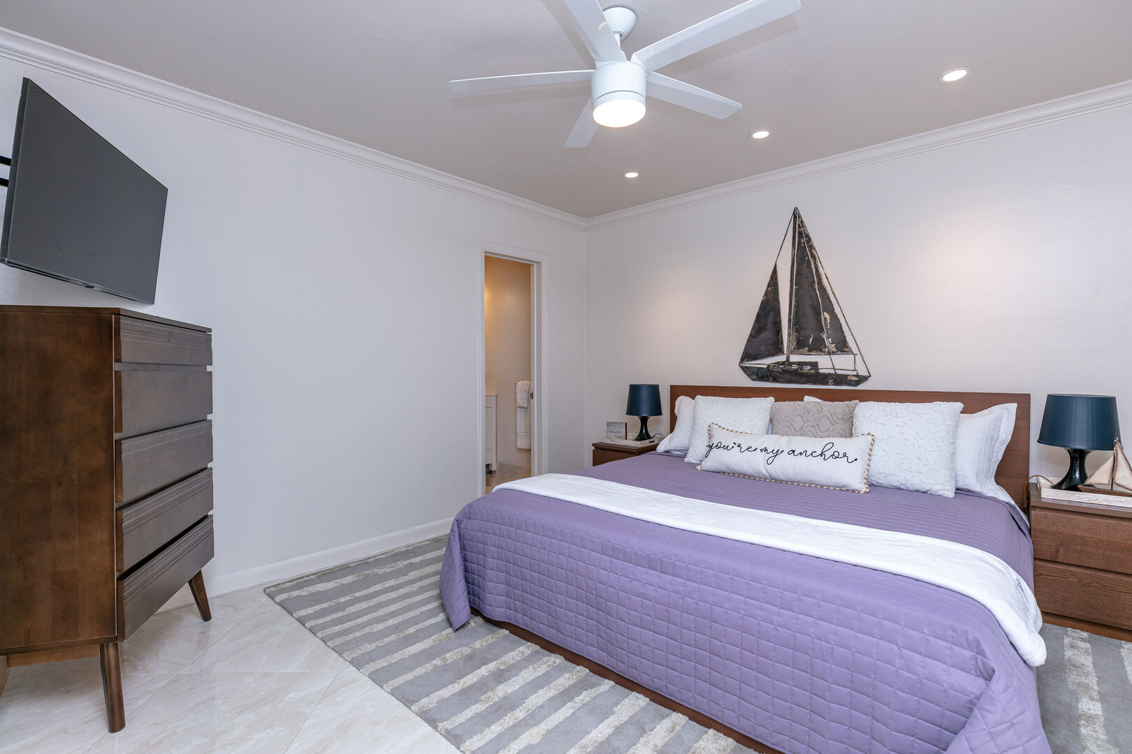 The master bedroom features a king-sized bed and a wall-mounted 40" Smart TV. There's also a nice dresser to store your clothes during your stay.