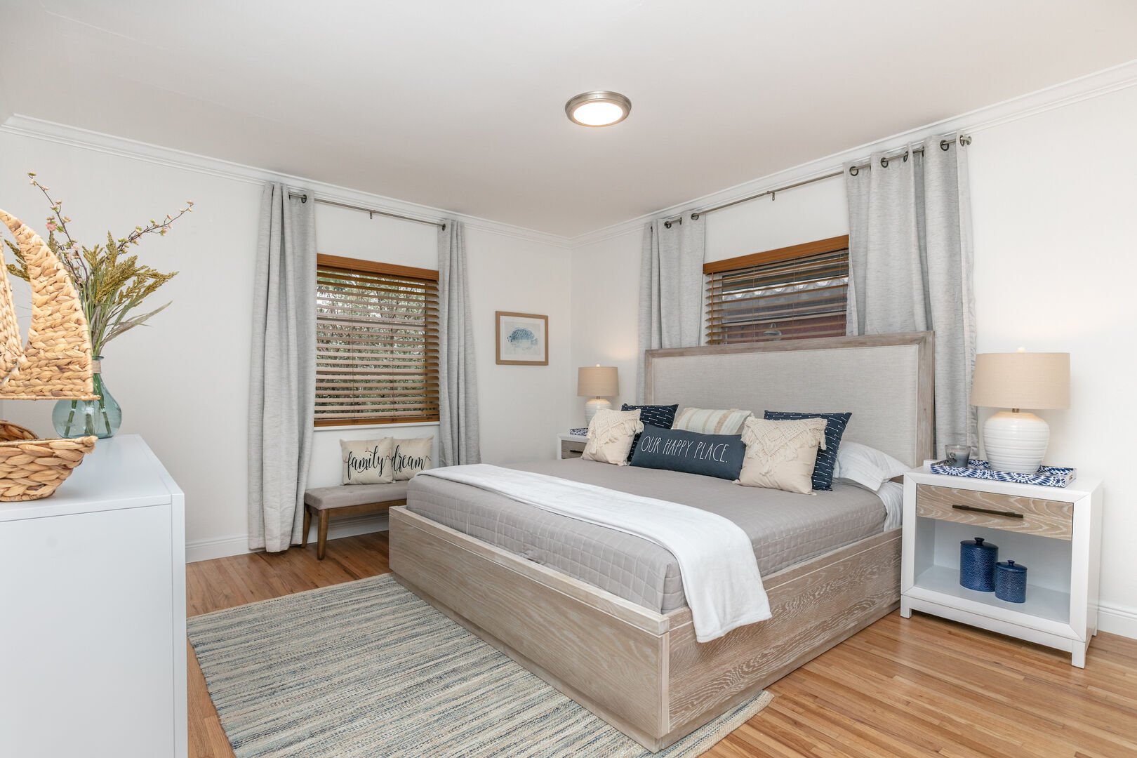 The master bedroom features a comfortable king-sized bed, a dresser, and a Smart TV