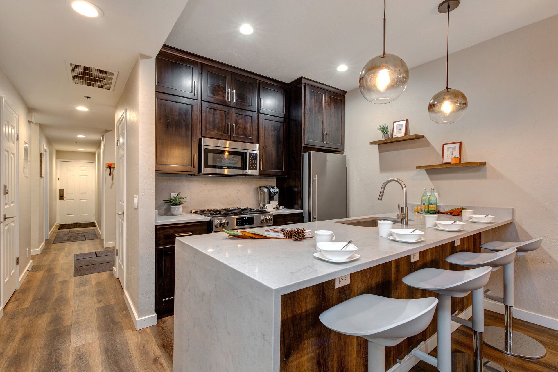 Fully Equipped Kitchen with gorgeous stone countertops, stainless steel appliances, and bar seating for four