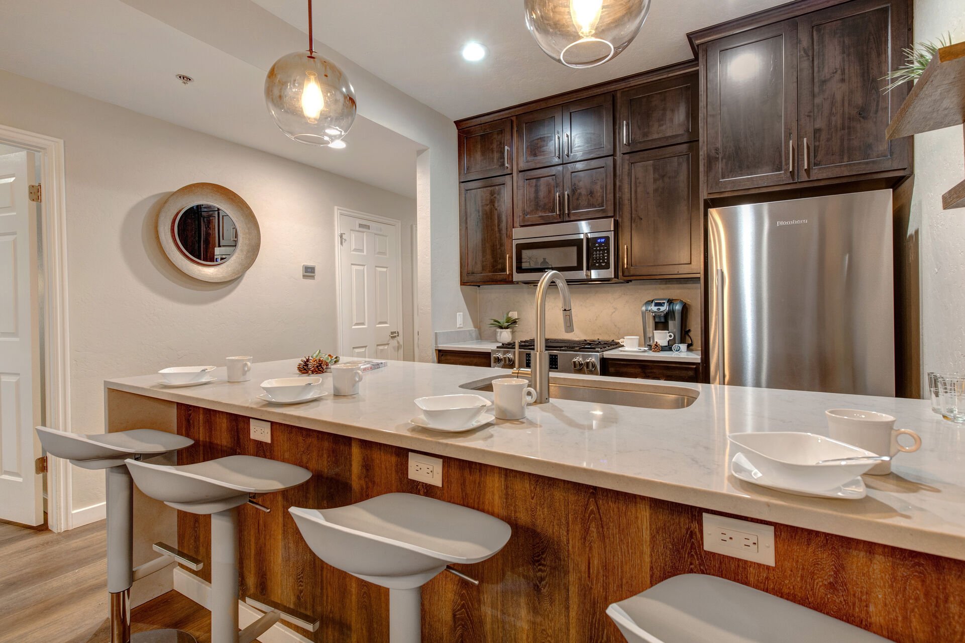 Fully Equipped Kitchen with gorgeous stone countertops, stainless steel appliances, and bar seating for four