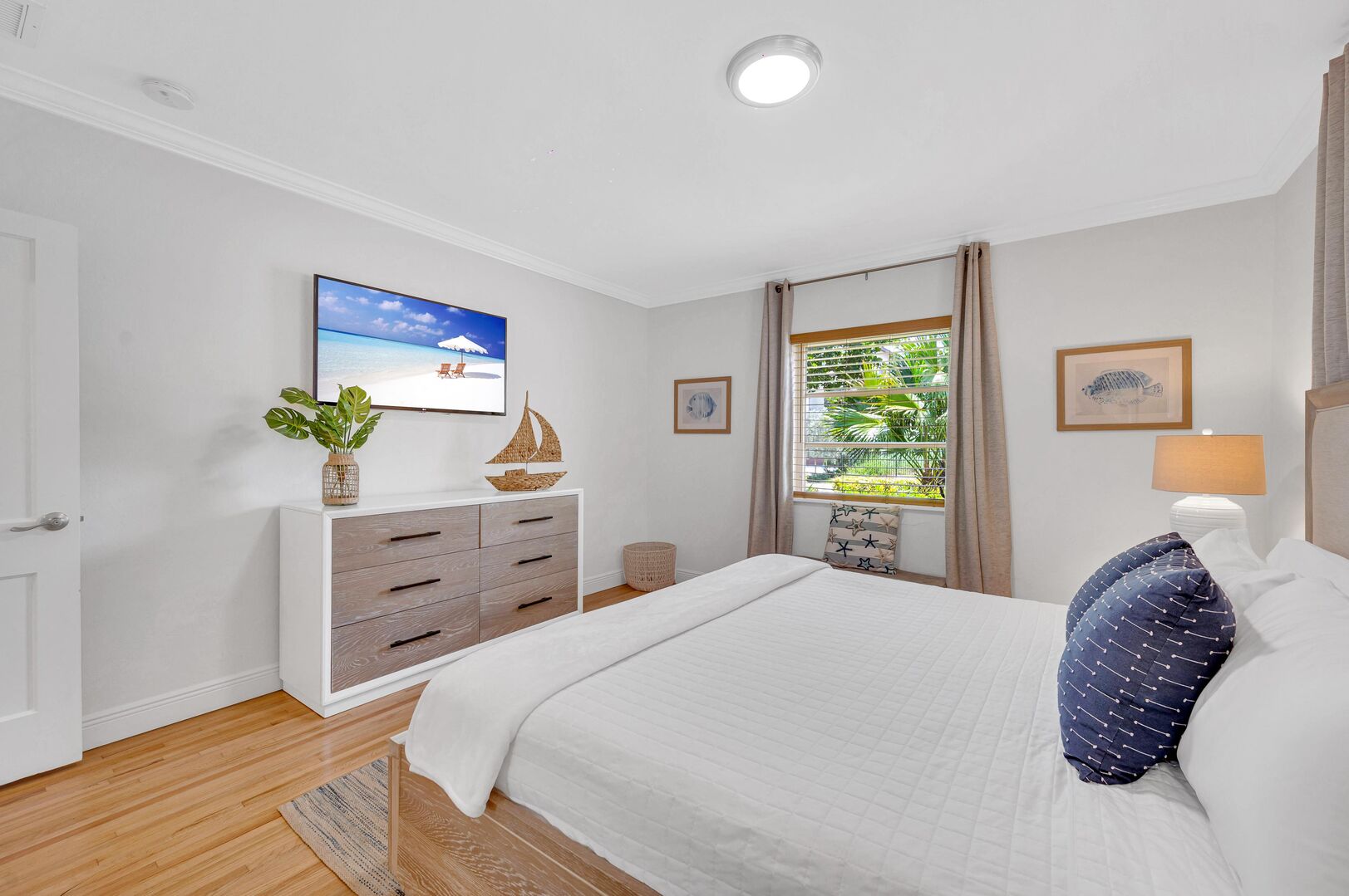 The master bedroom features a comfortable king-sized bed, a dresser, and a Smart TV.
