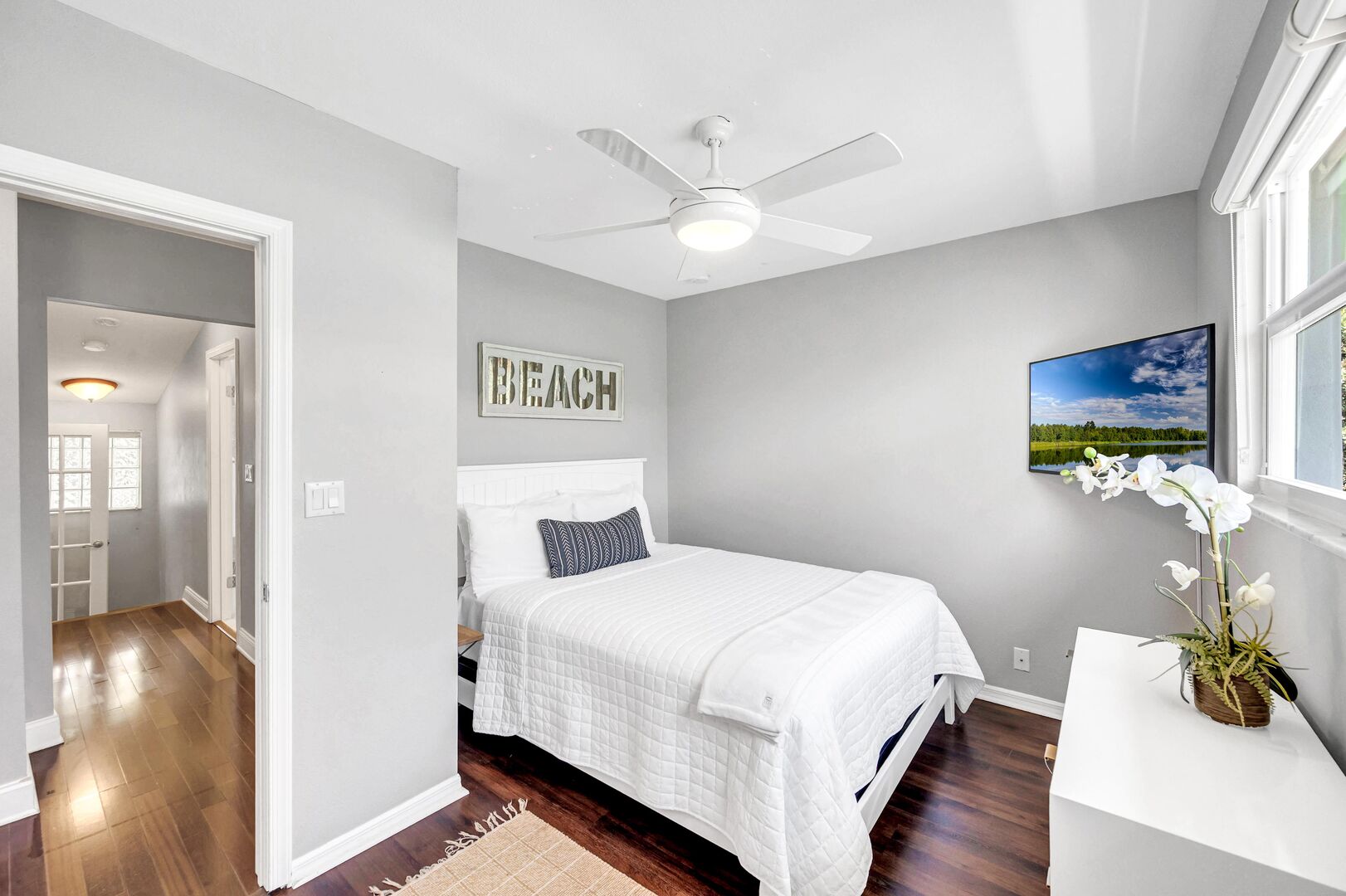 The third guest bedroom offers a queen-sized bed, a dresser and a smart T.V.