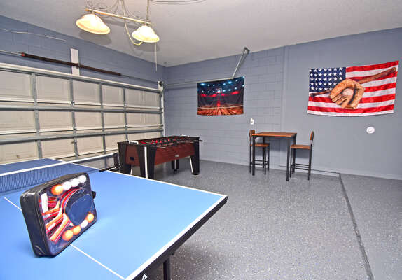 Converted garage has ping pong table, foosball and high top seating.