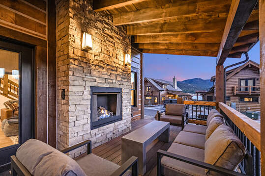 Cozy outdoor patio with hot tub, fireplace and seating area