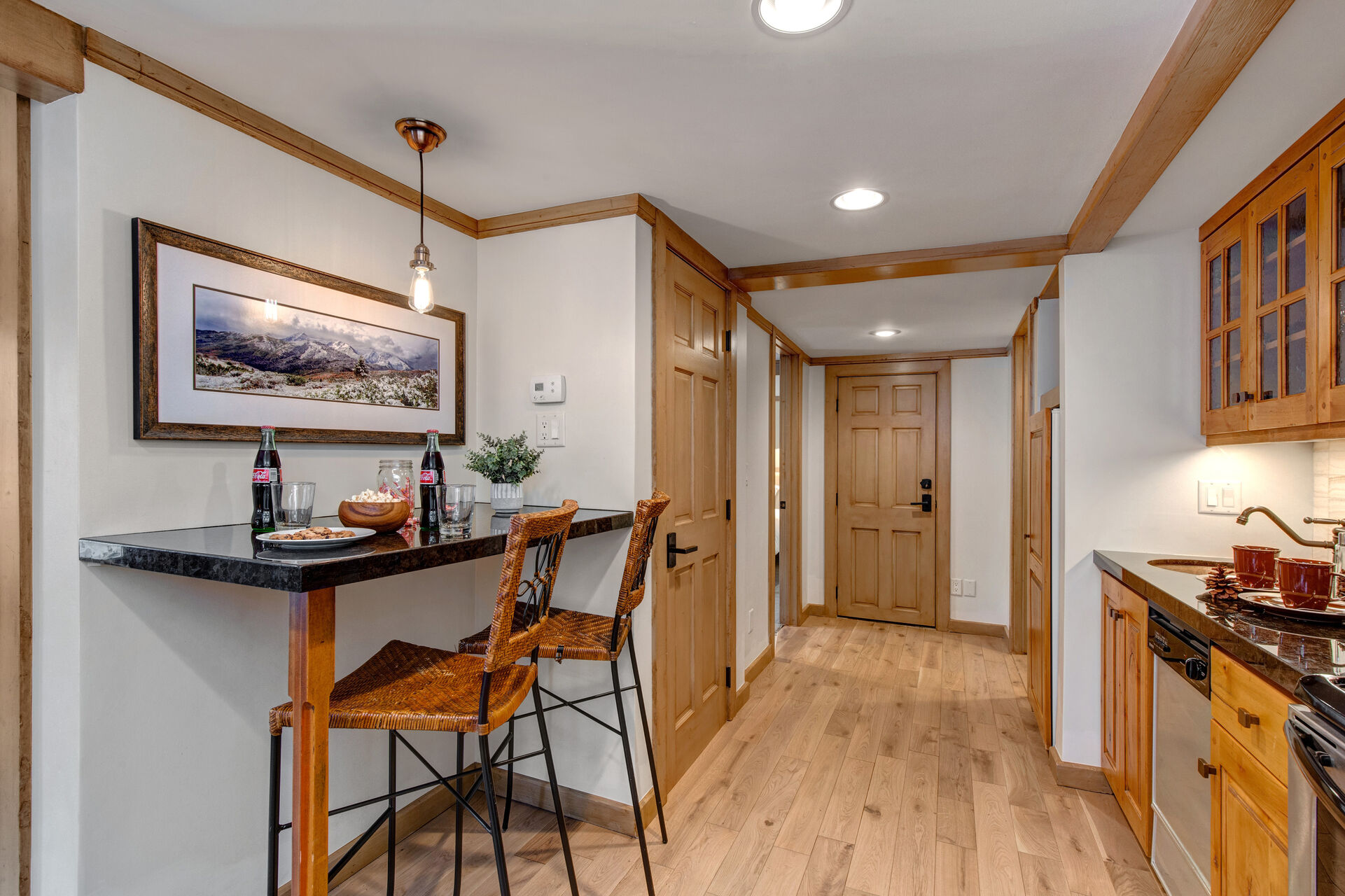 Lower Level Kitchenette with bar seating for two, stainless steel appliances and hot tub patio access