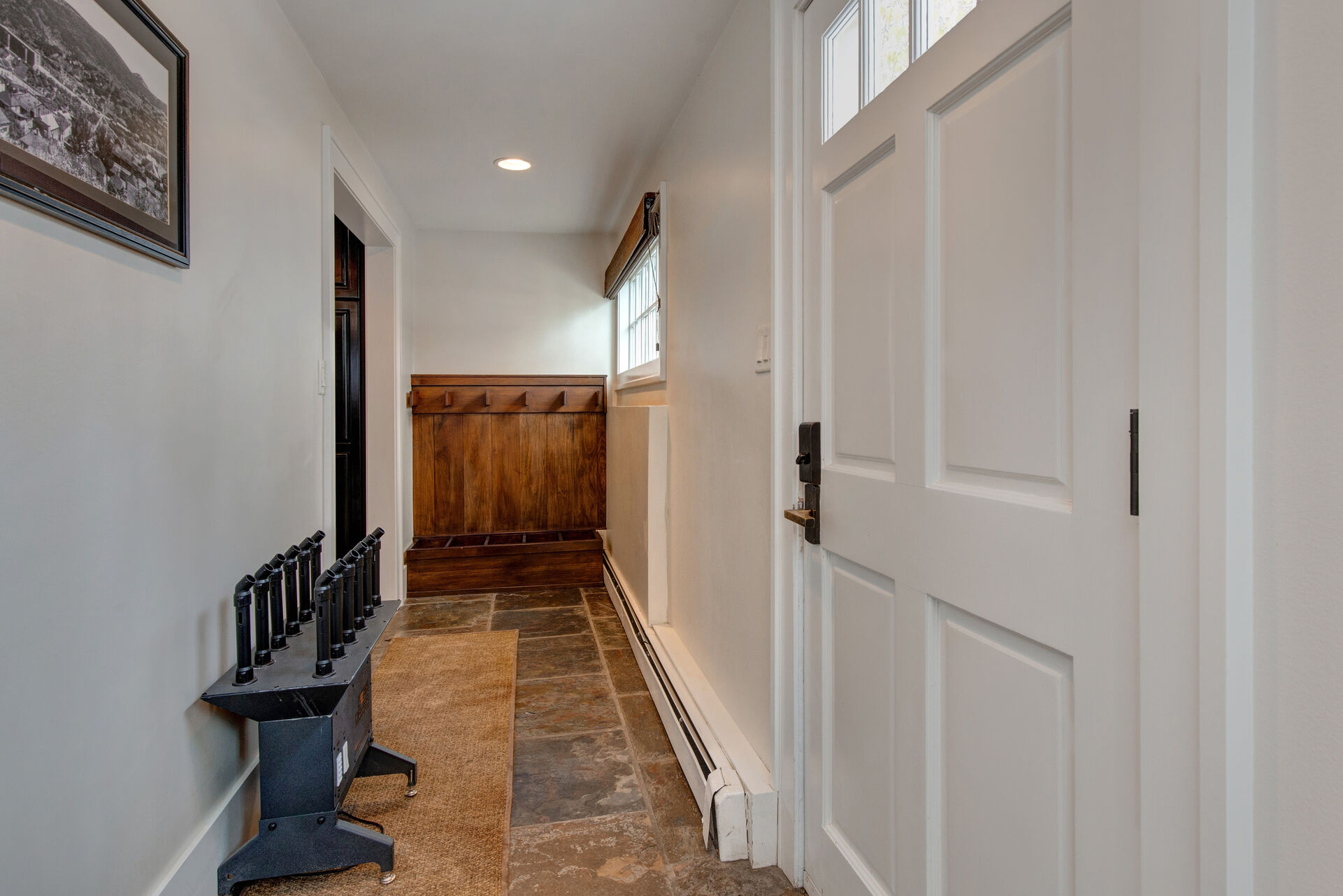 Secondary Mudroom Entryway with boot dryers, hooks, and storage