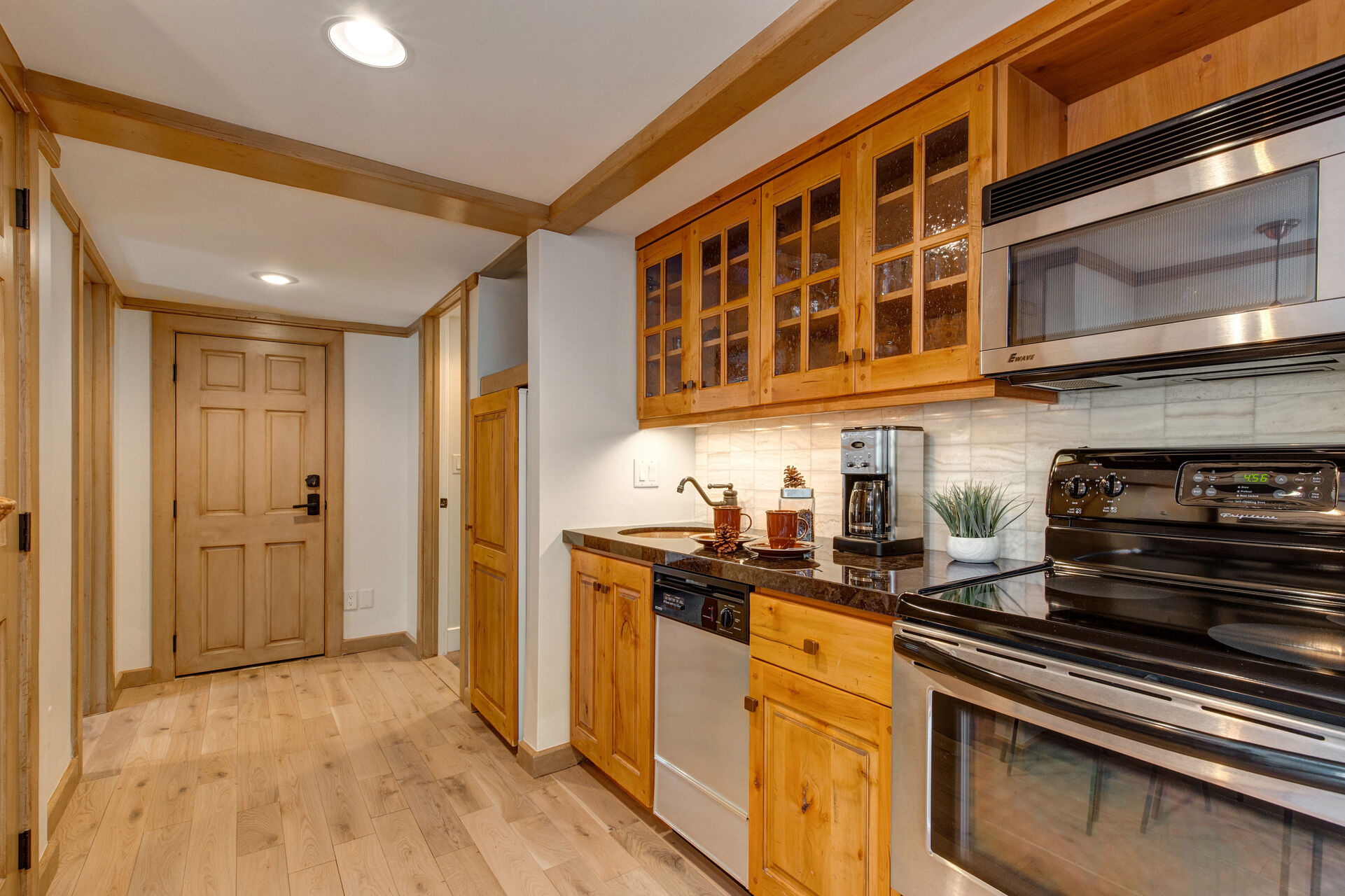 Lower Level Kitchenette with bar seating for two, stainless steel appliances and hot tub patio access