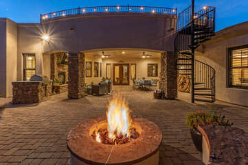 A beautiful covered patio and gas fire pit are part of the backyard paradise. Spiral staircase leads to rooftop deck.