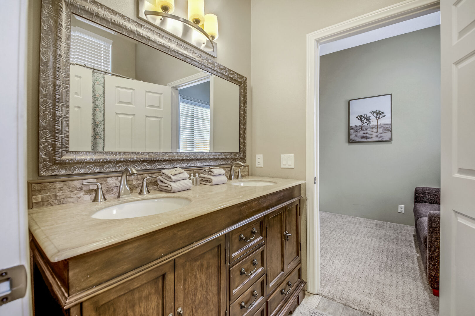 Shared, jack and jill bathroom with Bedrooms 2 & 3 features a shower and tub combo, and double vanity sinks.