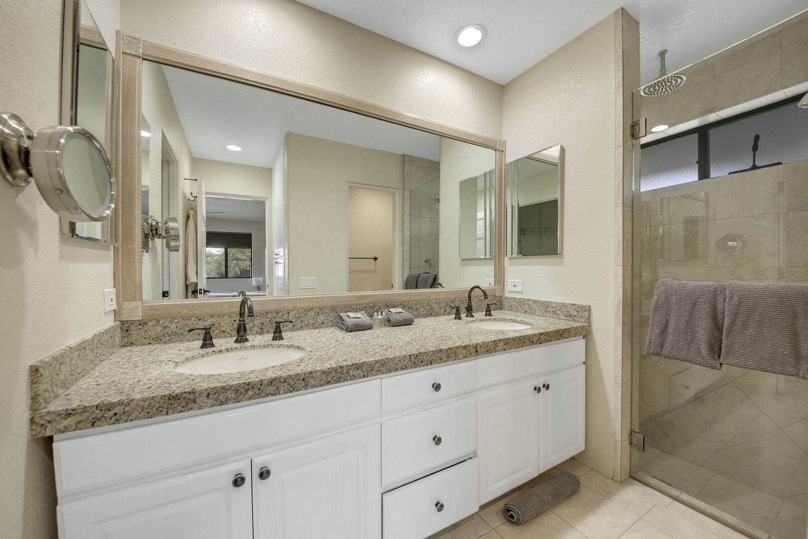 The private, en suite bathroom features a tile shower, and his and her vanity sinks. 