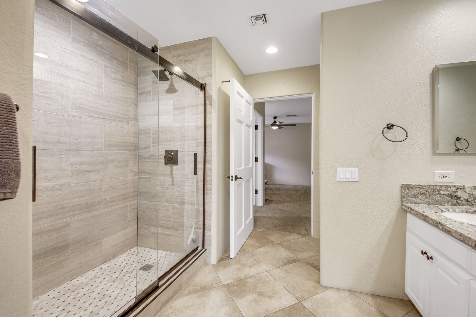 Shared, jack and jill bathroom features a tile shower, and double vanity sinks.