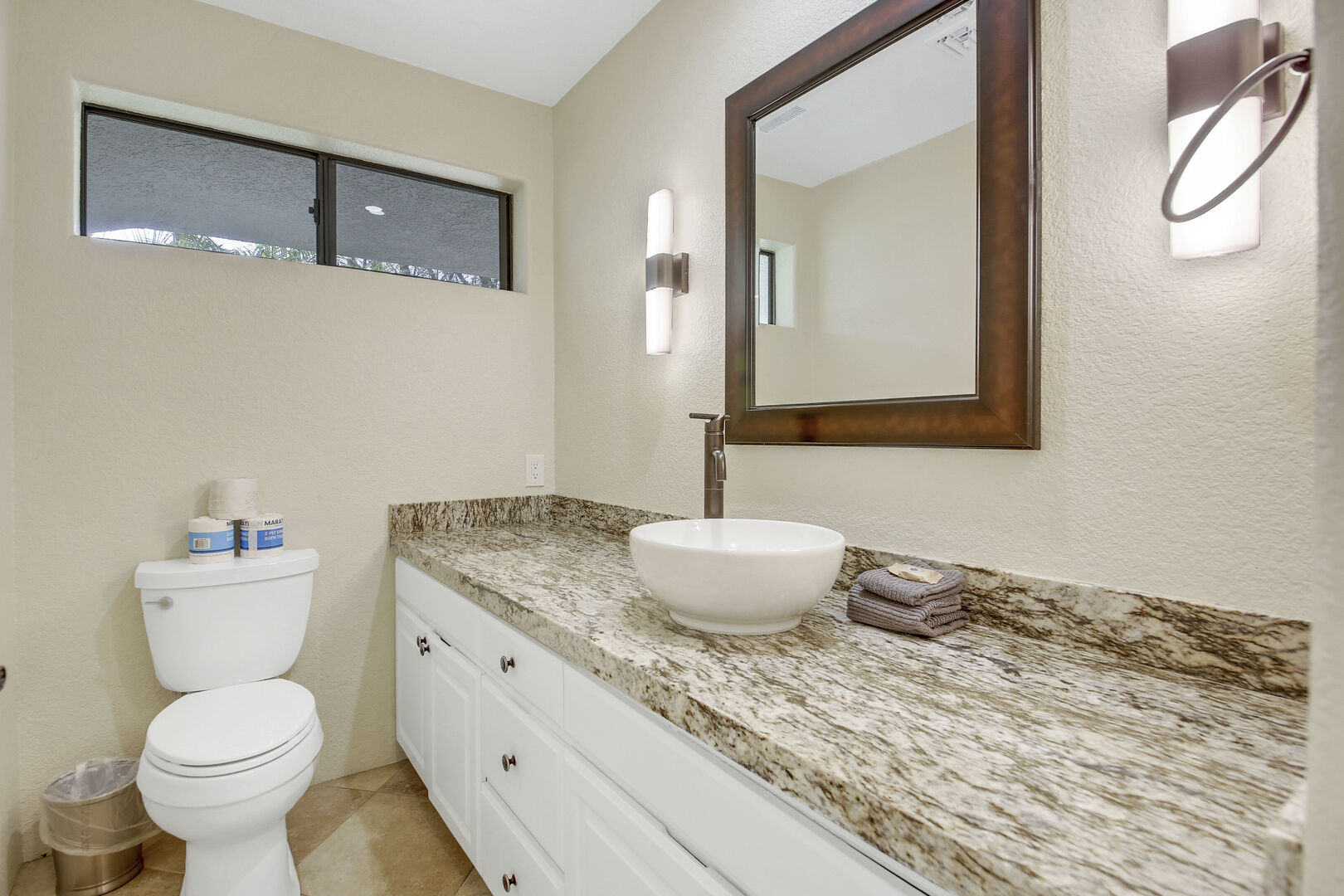 The powder room is located next to the front entry and features a vanity sink.
