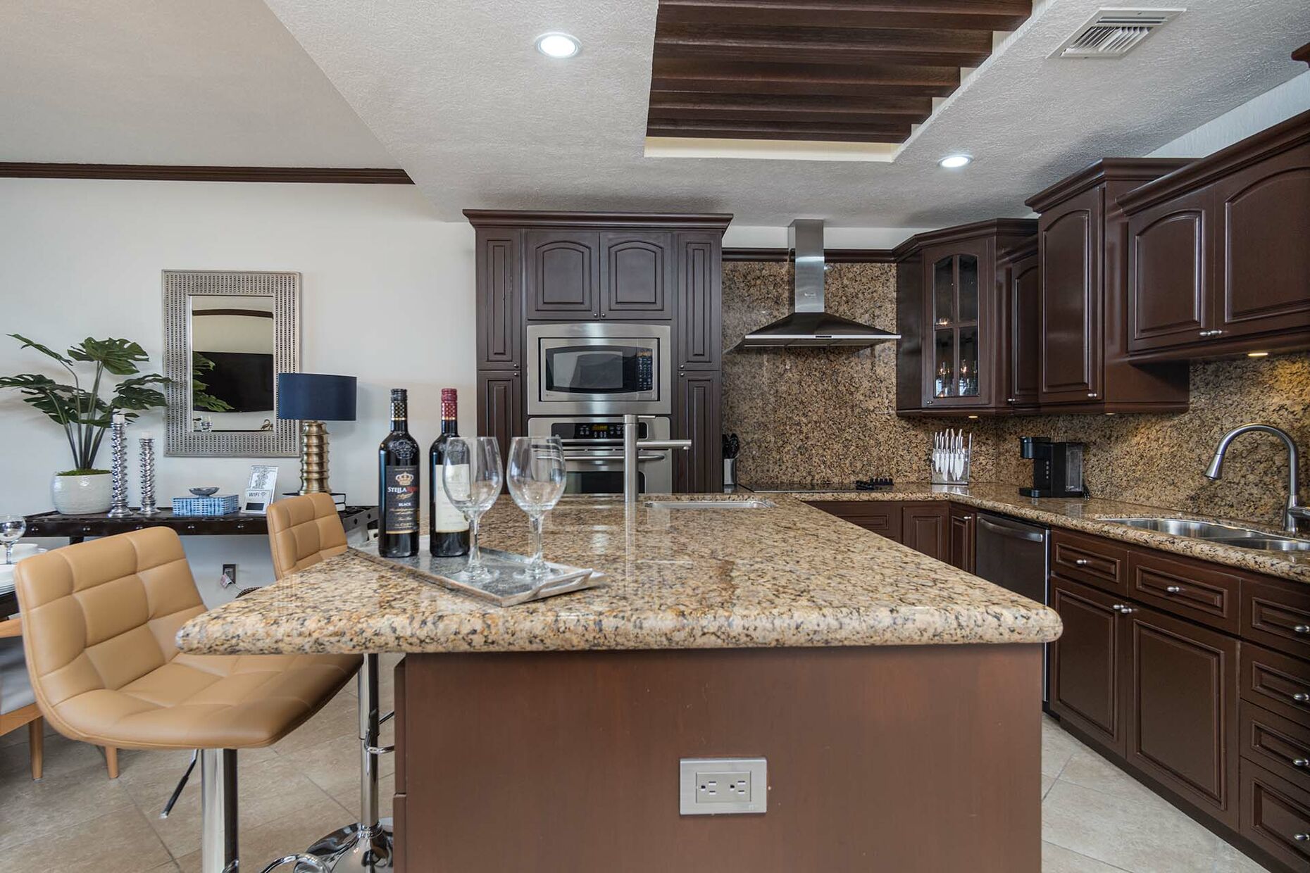 The kitchen with dark wood cabinets, modern appliances, and granite counter.