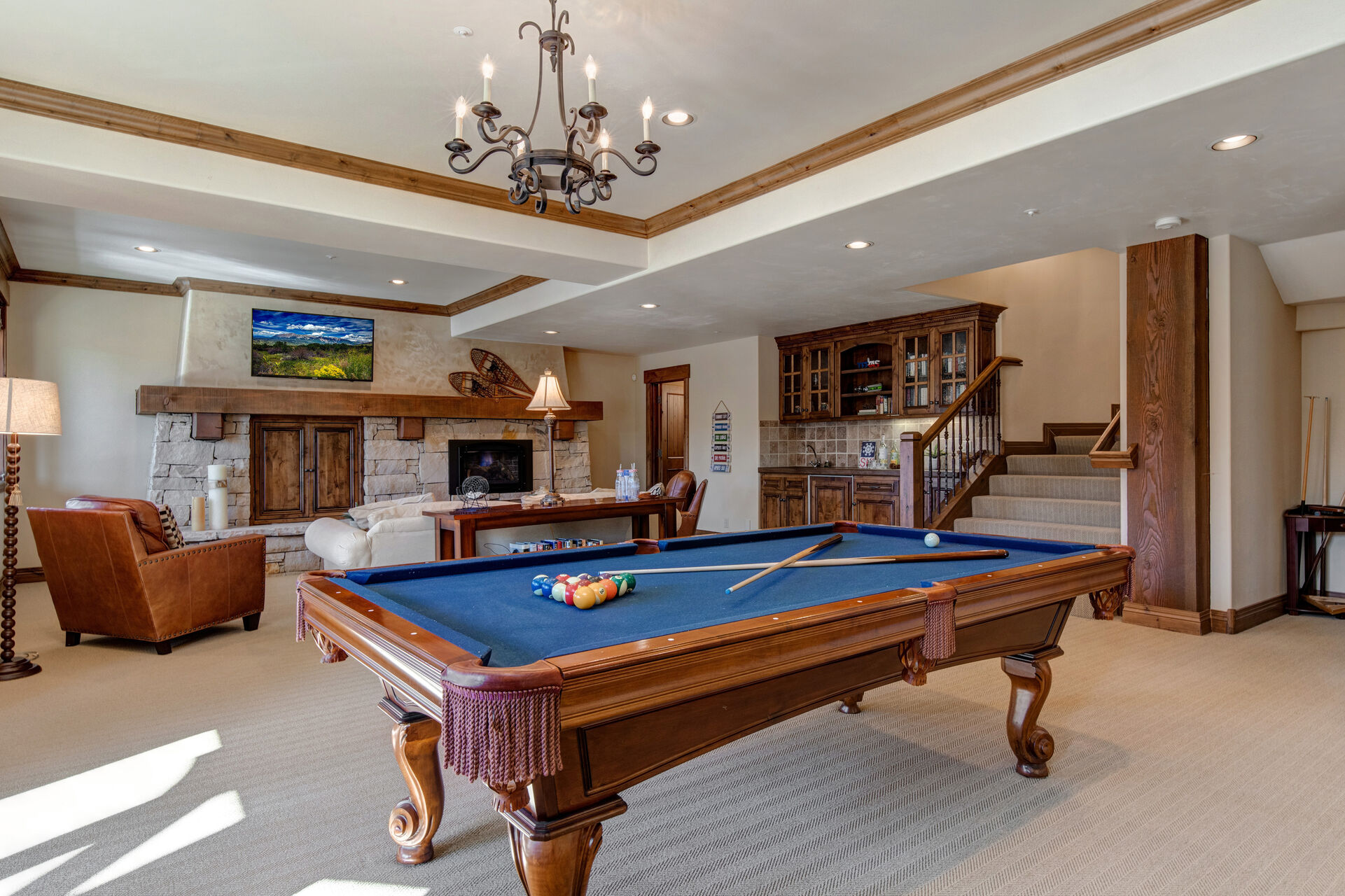 Lower Level Living and Game Room with plush sofa, leather arm chairs, gas fireplace, smart tv, wet bar, powder room, and billiards table