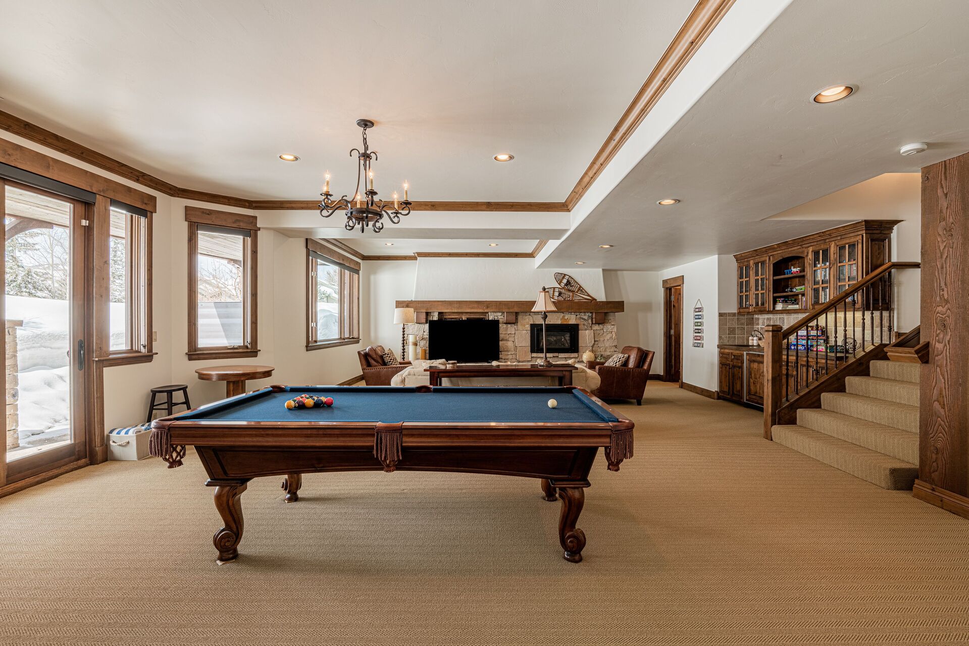 Lower Level Living and Game Room with plush sofa, leather arm chairs, gas fireplace, smart tv, wet bar, powder room, and billiards table