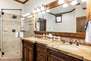 Master Bathroom with double sinks, large tiled shower, walk-in closet, and jetted tub
