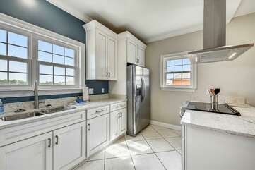 Tiled kitchen with stainless steel appliances.