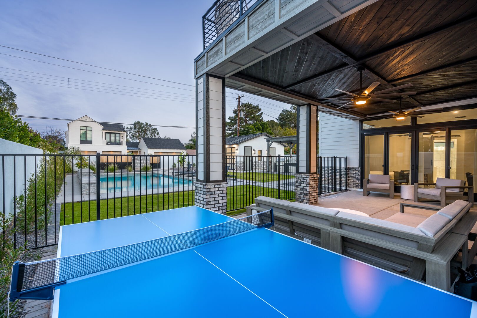 Ping Pong Table w/ Fenced Pool in Background