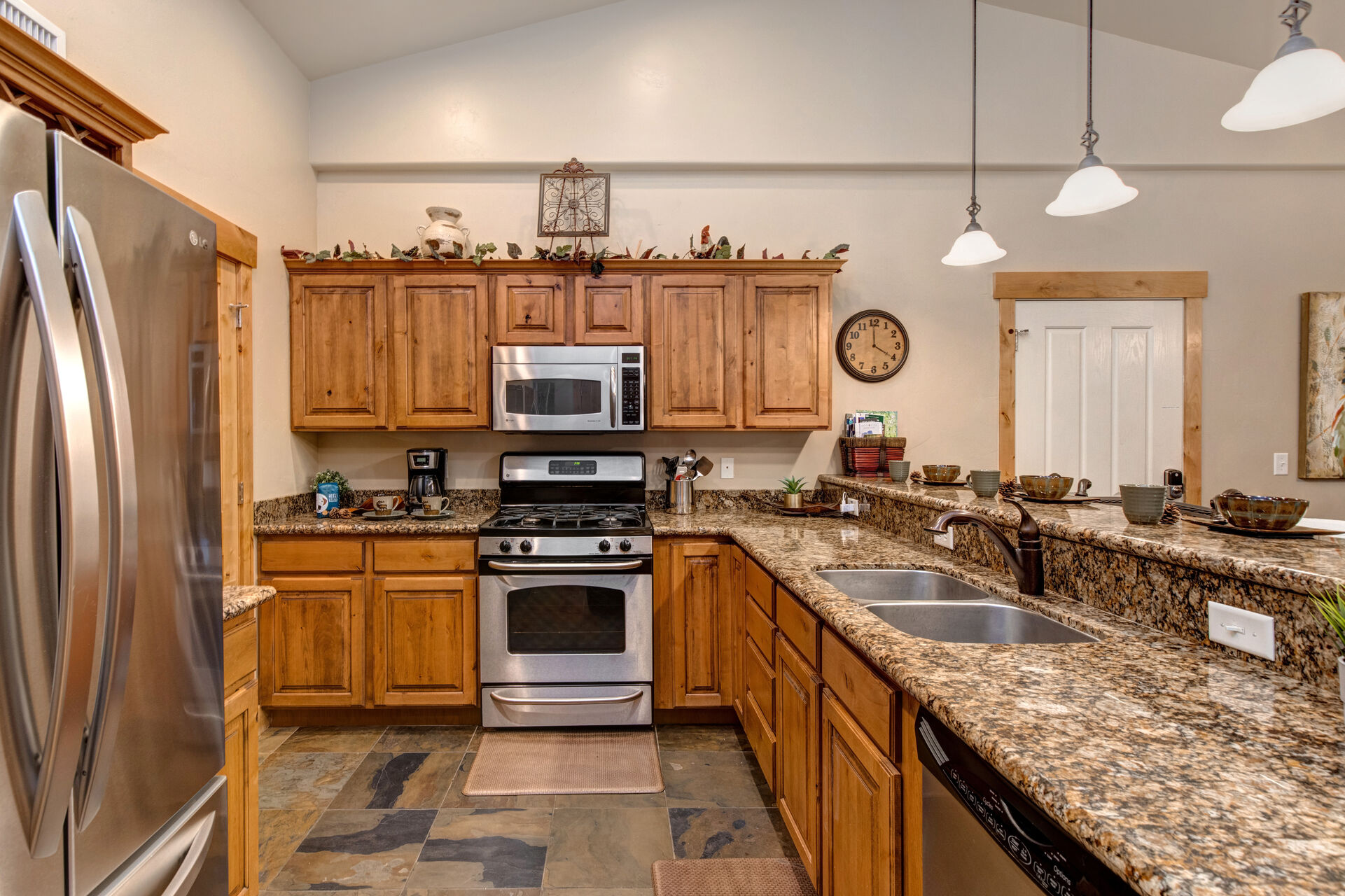 Fully Equipped Kitchen with beautiful stone countertops, stainless steel appliances, and bar seating for four