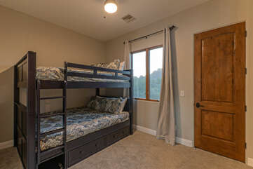 Bedroom 2 has queen size bunk beds with a top safety rail and TV.