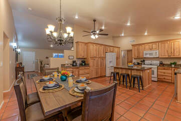 Modern and well stocked kitchen opens into a dining area with table seating.