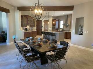 The kitchen opens into a formal dining area with views of the backyard and Superstition Mountains.