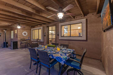 Outdoor dining is a treat on the covered back porch with large TV.