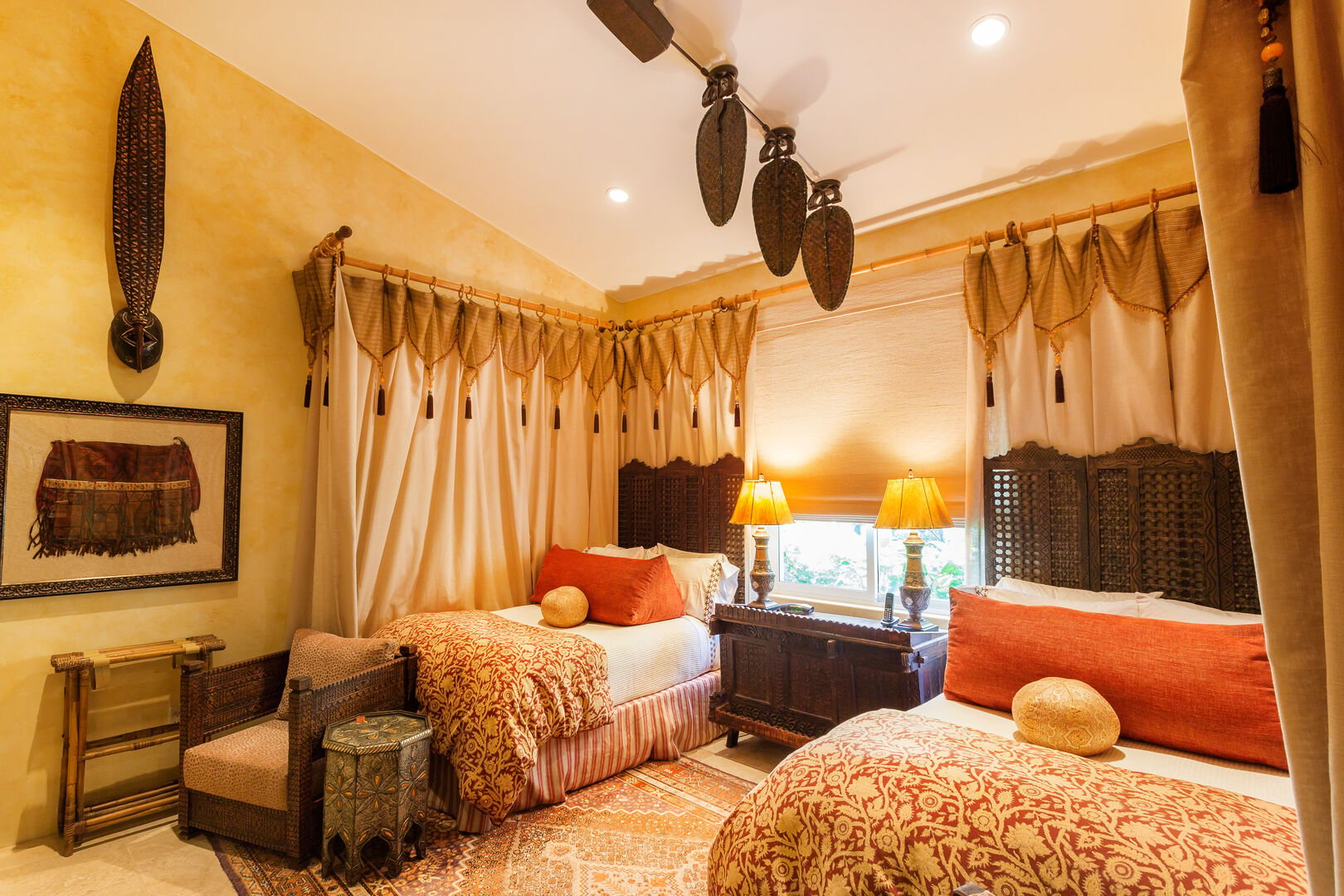 Bedroom with two beds, ceiling fan, nightstand, and table lamps