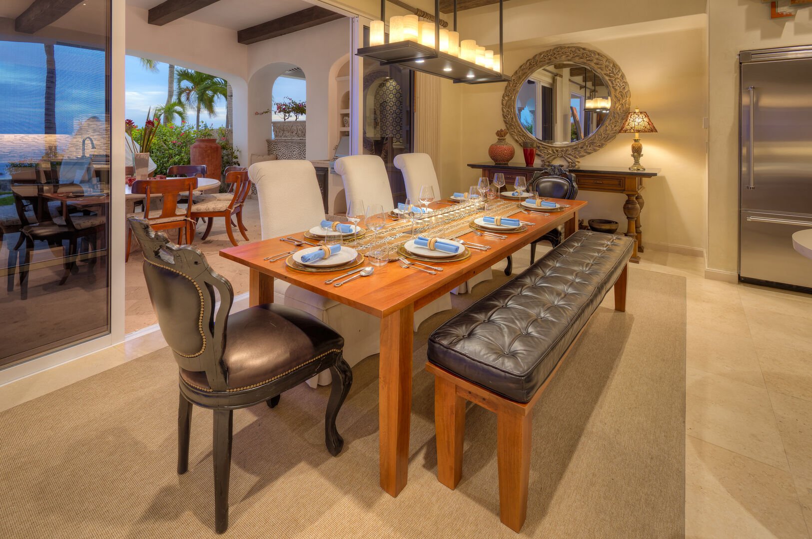 Dining table, chairs, mirror, refrigerator, and sliding glass doors to the terrace