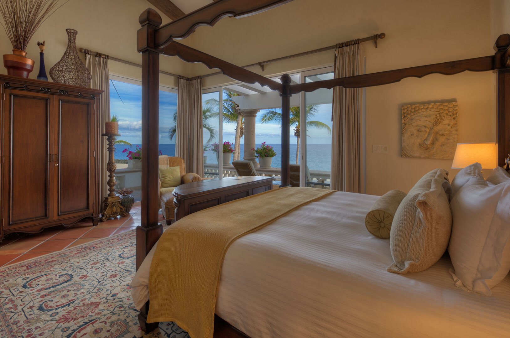 Bedroom with a private ocean view balcony, a large bed, and an armoire