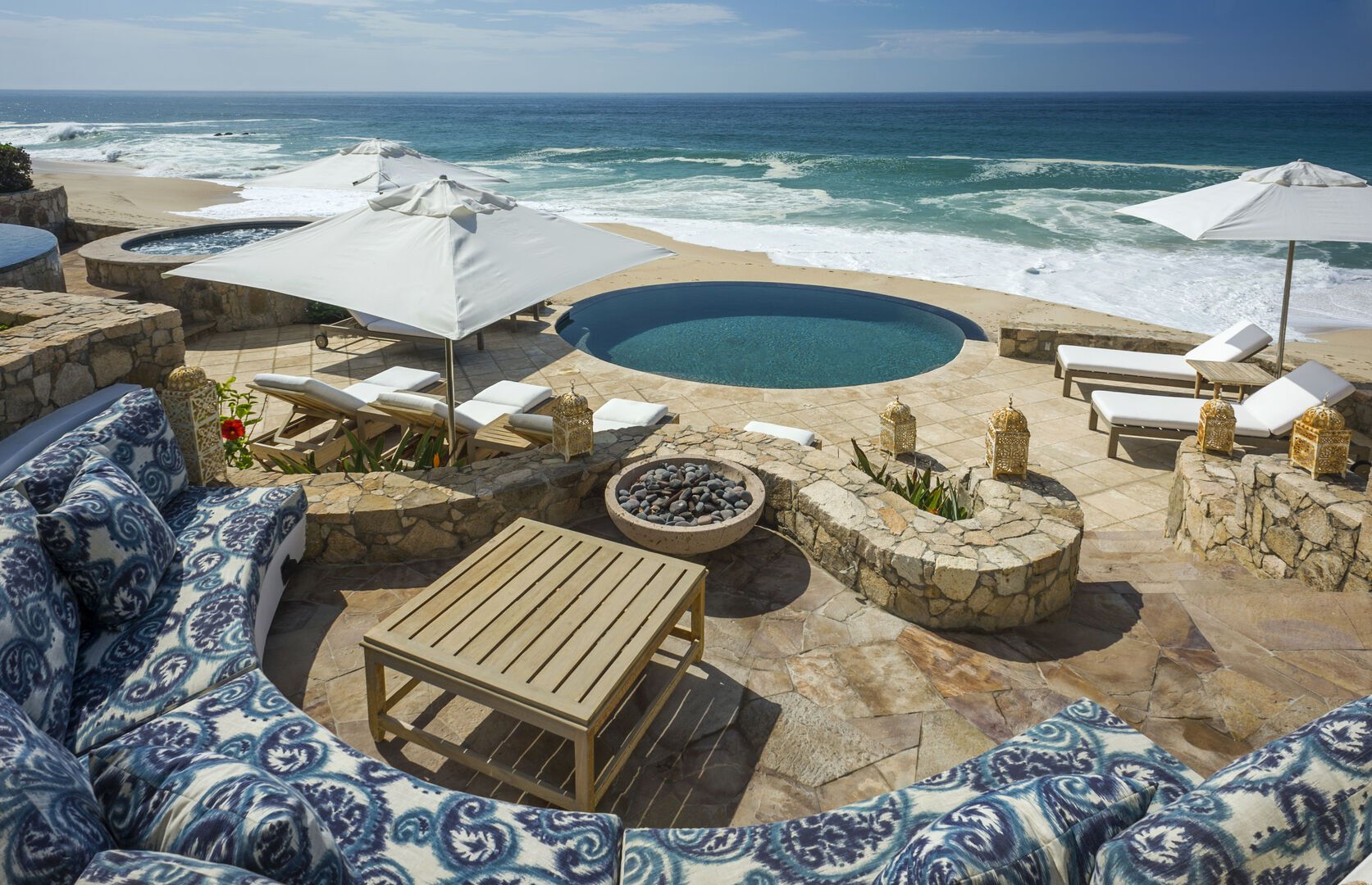 Outdoor lounge area with lounge chairs, parasols and a pool