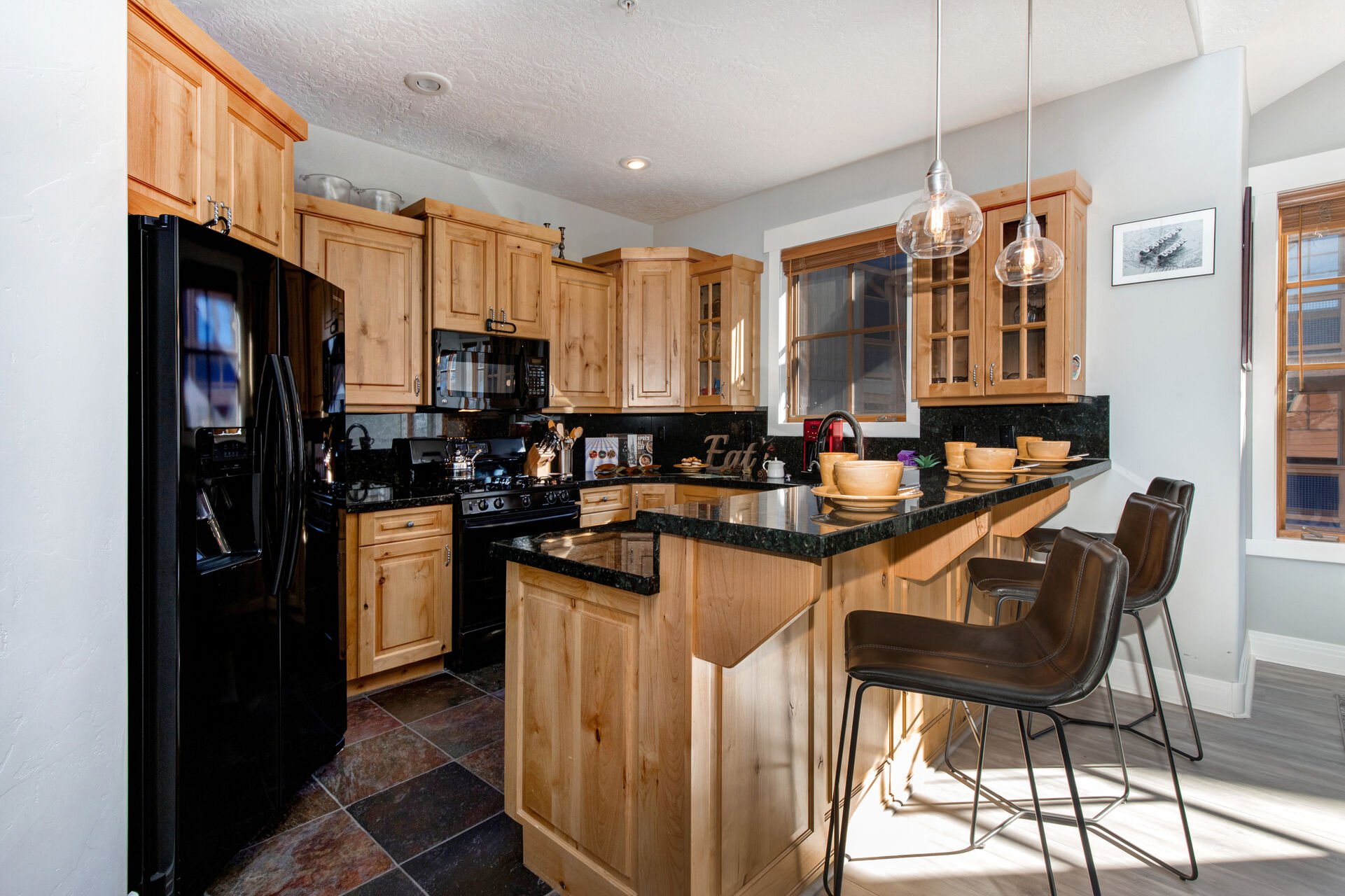 Fully Equipped Kitchen with stone countertops, ice-maker, and bar seating for 3