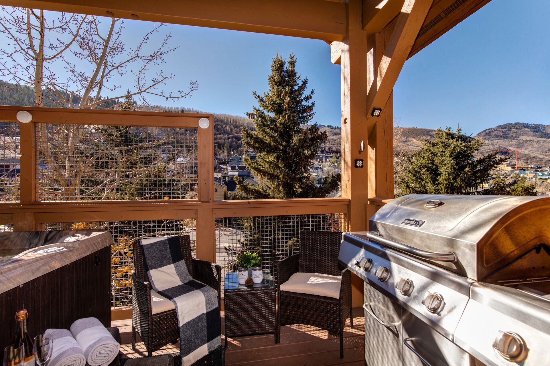 Private balcony off living room with BBQ grill, seating for 2, and hot tub