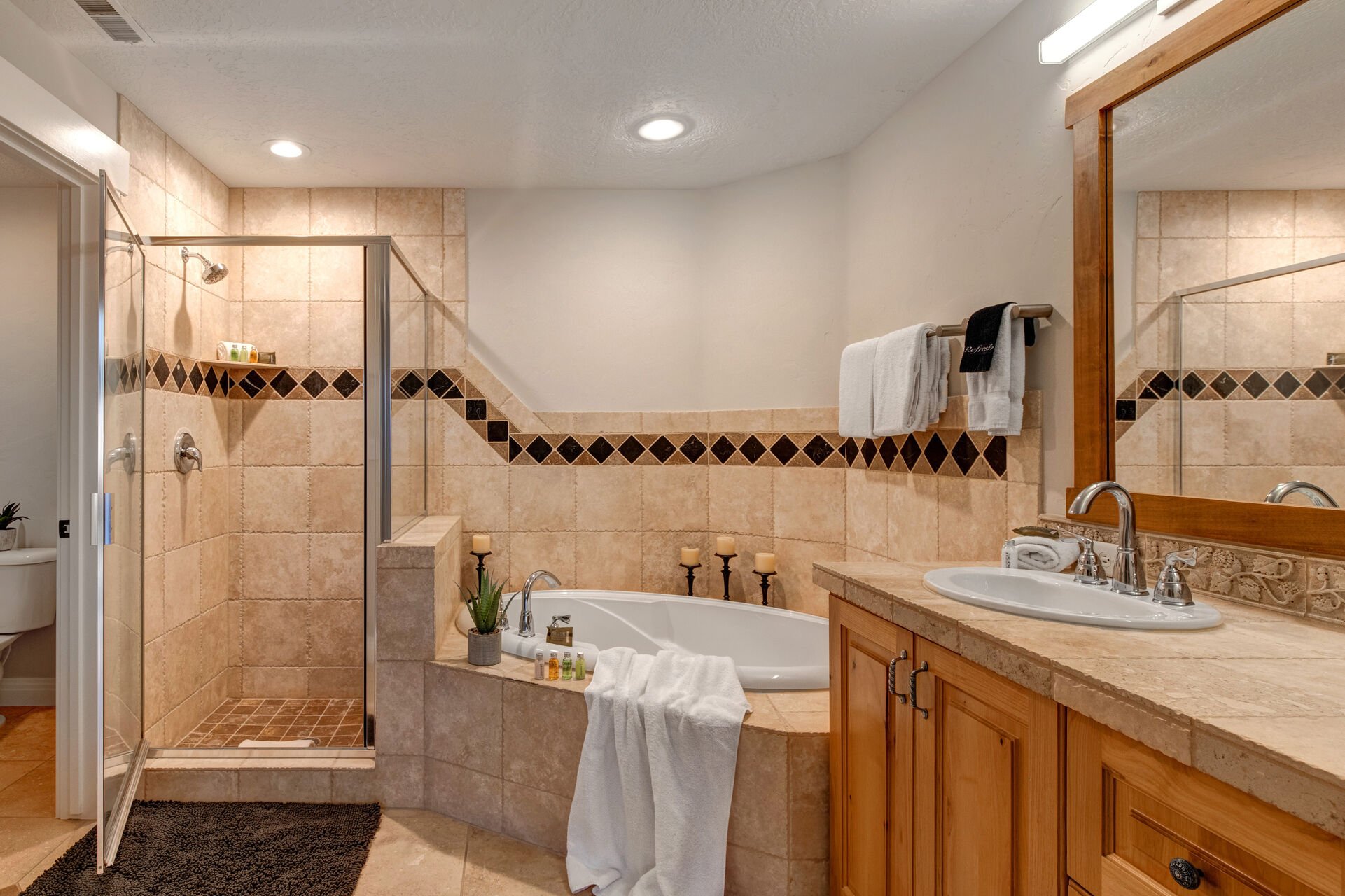Master Bathroom with double sinks, soaking tub, tiled shower, and walk-in closet
