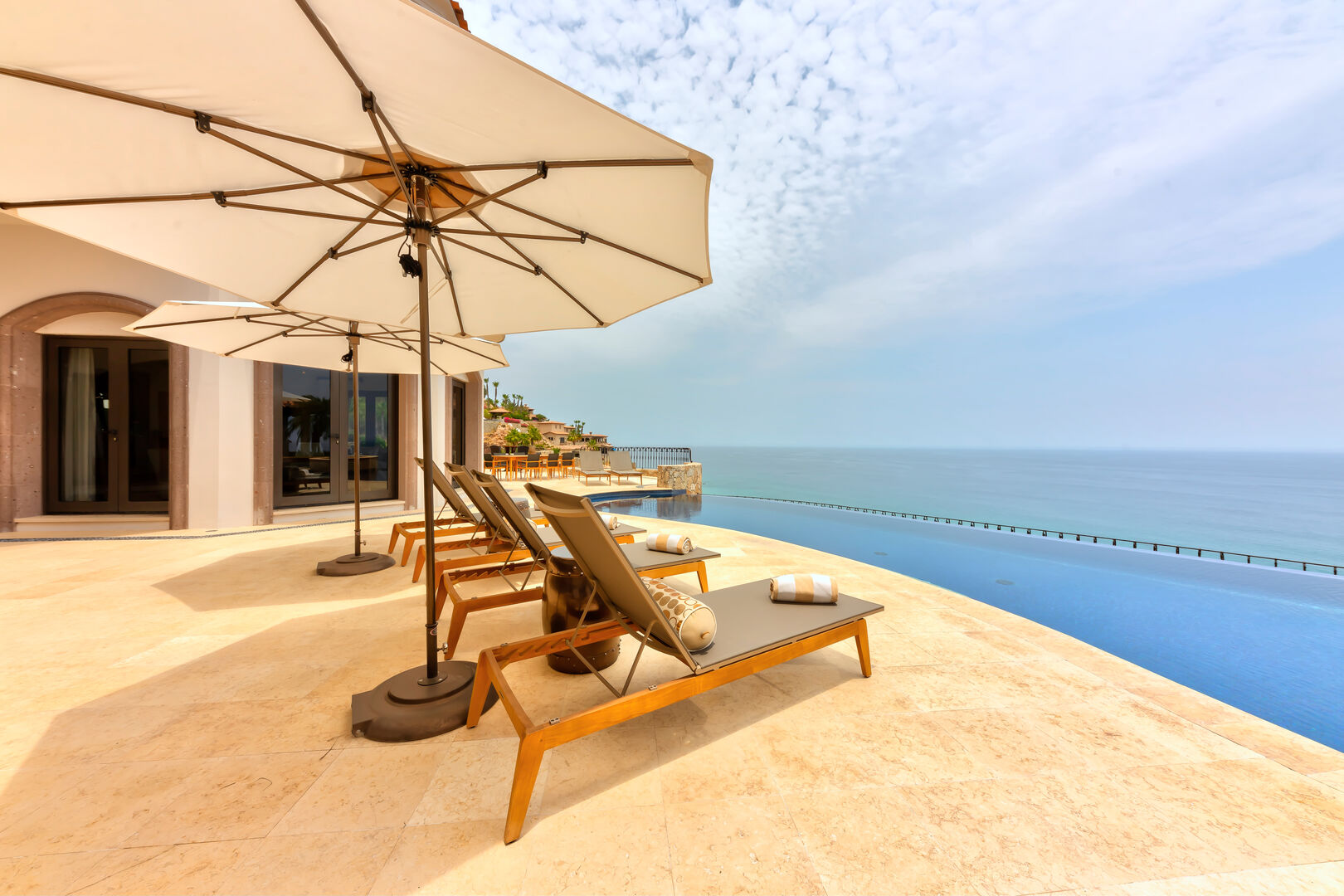Lounge chairs with umbrellas overlooking the ocean at Hacienda 502