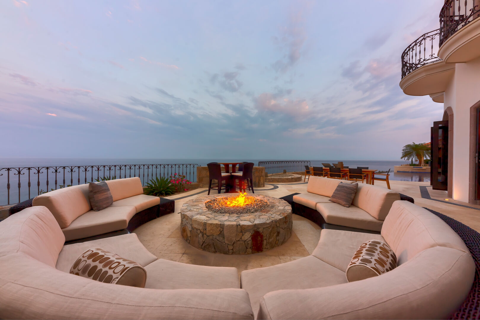 A lit fire pit surrounded by chairs at Hacienda 502