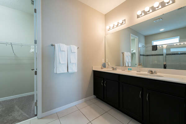 Downstairs master suite bath with large shower and dual sink vanity.